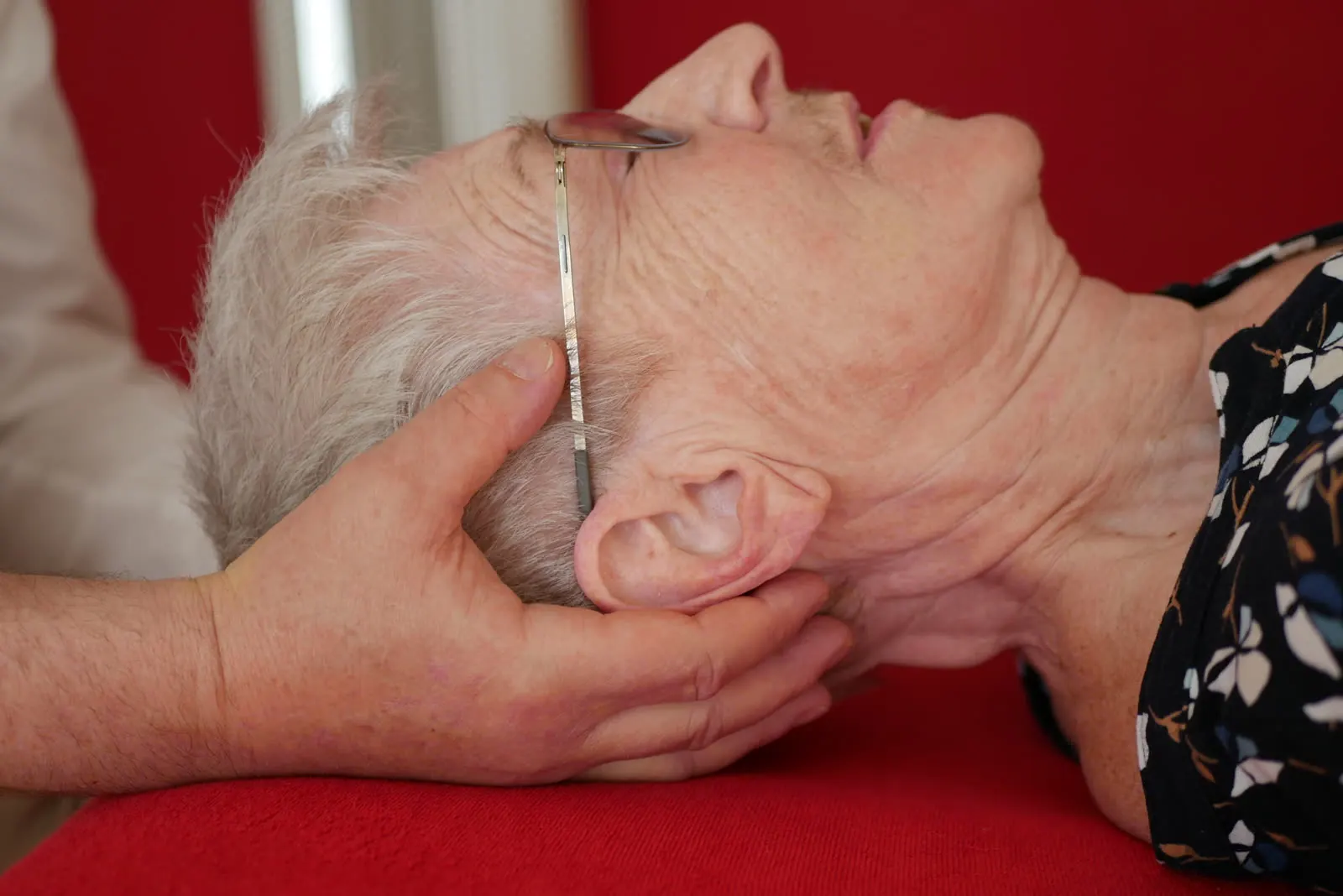 Sanfte craniosacrale Behandlung, die Hände liegen am Kopf